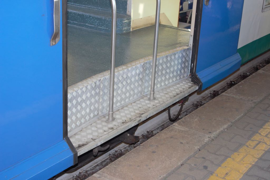 Vista del excesivo escalón de acceso desde el andén a un coche de dos pisos con la puerta sobre el bogie