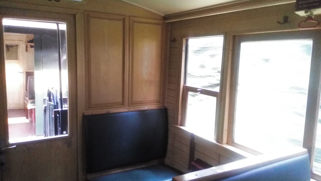Interior de un vagón, repartido en 3 compartimentos de 8 asientos. Todo de madera.
