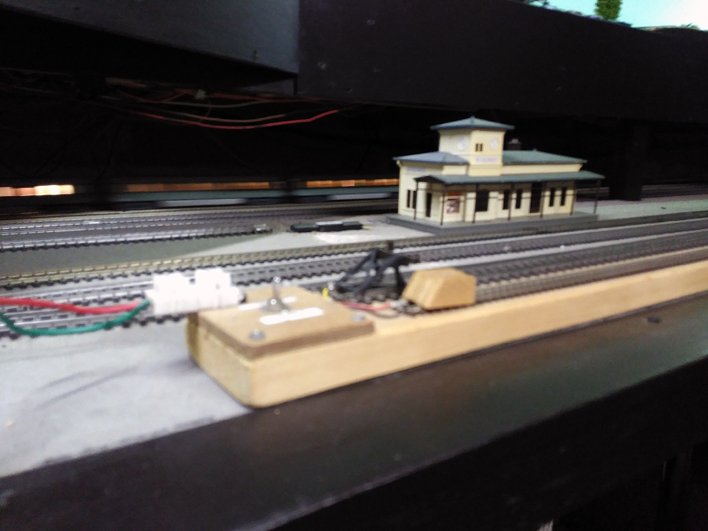 Parte inferior de la maqueta de H0. Al fondo pasa tren iluminado