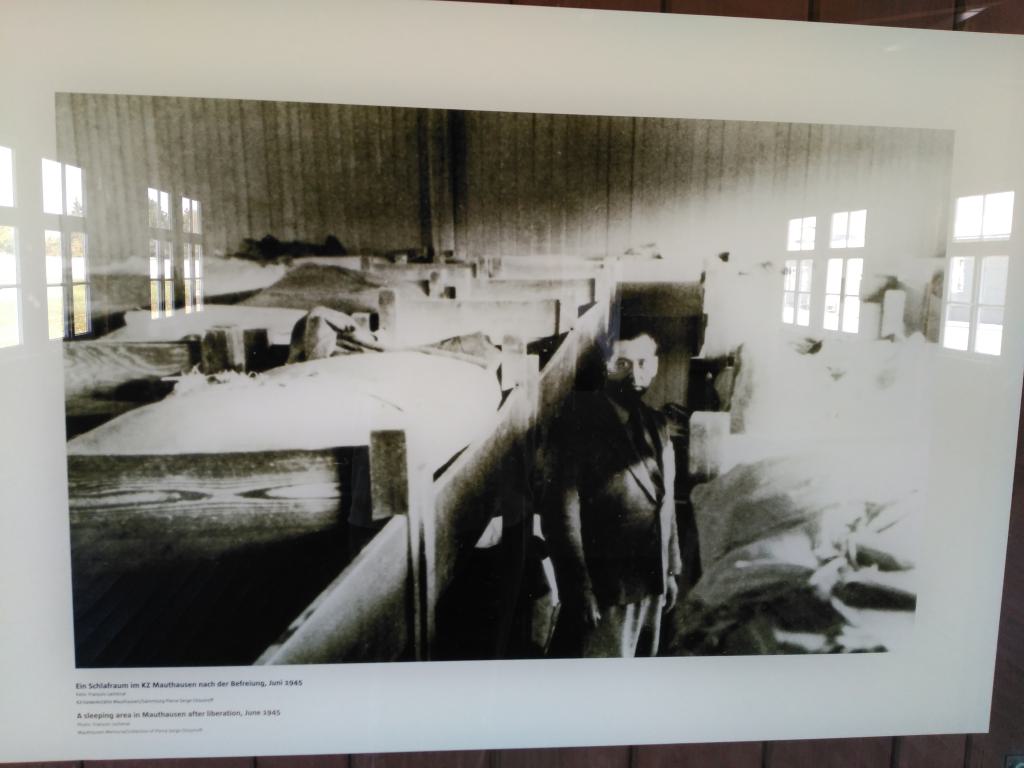 Foto antigua del interior de un barracón con el reflejo actual de sus ventanas